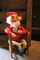 K&Co. presents: 
Old shop 
Santa in felt 
clothes and 
clogs sitting 
in an old 
wicker chair...