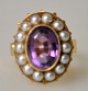 Pegasus – Kunst 
- Antik - 
Design 
presents: 

Finger 
ring in red 
gold, 14 k, 
with 14 pearls 
and amethyst.