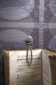 K&Co. presents: 
Old 
bookmark in 
silver 
(Stamped) with 
flower at the 
top.