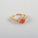L'Art presents: 
14 karat 
gold ring 
adorned with an 
orange opal and 
numerous 
brilliant-cut 
diamonds.