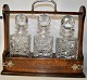 Pegasus – Kunst 
- Antik - 
Design 
presents: 
Tantalus 
of oak with 
three crystal 
decanters with 
stoppers. 
England. ...
