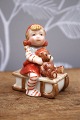 K&Co. presents: Royal Copenhagen Pixie in porcelain, no.764. Girl on a sled with a small teddy bear.