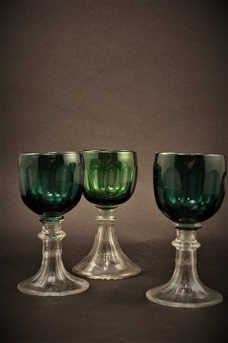 Gamle , 1800 tals hvidvins glas med fine slibninger i grøn farve med klar fod. 
Højde:13cm. Dia.:6cm.