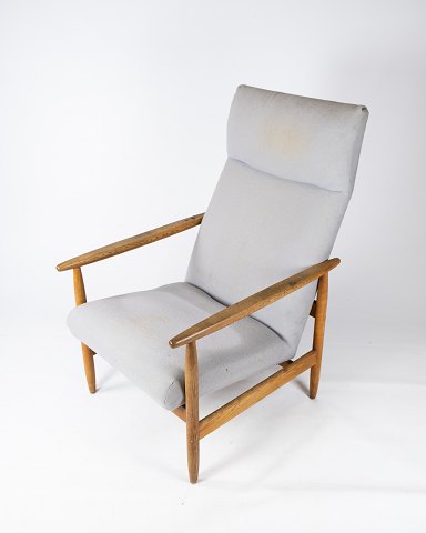 Lænestol, model J65 af lyst træ og polstret med gråt uldstof designet af Ejvind 
A Johansson for FDB.
5000m2 udstilling.