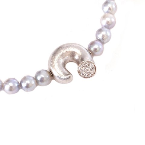 Ole Lynggaard Copenhagen 14kt whitegold clasp "The 
Optimist" with a Lynggaard pearl necklace. Clasp: 
18x18mm. Necklace: 42cm