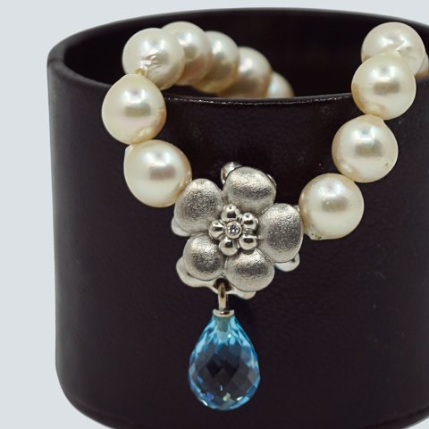 Ole Lynggaard, Charlotte Lynggaard; Blomsterlås af 18 kt. hvidguld med topas og diamant