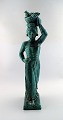 Harald Salomon for Rörstrand, green glazed stoneware/art pottery figure of a 
woman bearing fruits in a dish on her head.
