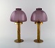 HANS-AGNE JAKOBSSON for A / B MARKARYD. A pair of oil lamps in brass and purple 
art glass. 1960 / 70