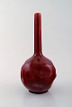 Rörstrand. Tidlig smalhalset vase i glaseret fajance. Smuk dyb rød glasur. Ca. 
1900.