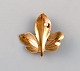 Scandinavian jeweler. Leaf-shaped brooch in 14 carat gold adorned with cultured 
pearl. Mid-20th century.
