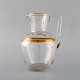 Baccarat, France. Art deco jug in mouth-blown crystal glass with gold decoration 
in the form of leaves. 1930s. Three pieces in stock.
