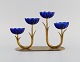 Gunnar Ander for Ystad Metall. Candlestick in brass and blue art glass shaped 
like flowers. 1950s.
