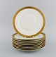 Royal Copenhagen service no. 607. 9 porcelain lunch plates. Gold border with 
foliage. Model number 607/9589. Dated 1946.
