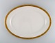 Royal Copenhagen service no. 607. Colossal serving dish in porcelain. Gold 
border with foliage. Model number 607/9592. Dated 1943.
