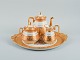 Le Tallec, France. Tea service on a large tray consisting of coffee pot, sugar 
bowl and creamer on a round tray.