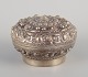 Chinese silversmith. Lidded jar richly decorated in relief with flowers and 
ornaments.