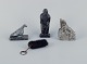 Greenlandica, three pieces of soapstone and a black pouch with a keyring. 
Features a ptarmigan, seal, and hunter.
