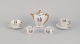 Limoges Porcelaine, Frankrig. 
Kaffekande, tekop og en kaffekop med underkopper samt to æggebægre i porcelæn. 
Motiver af børnemusikanter.