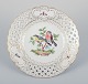 Meissen, Germany. Open lace porcelain plate. Hand-painted with a bird motif and 
insects, gold trim.