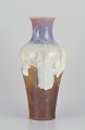 Sevres, France. Large unique porcelain vase with flowing glaze in ochre yellow, 
purple, and sand tones.
