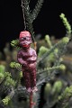 Old Christmas tree ornament in the shape of a small doll of a black African man 
in painted clay/plaster...