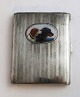 Alpaca cigarette case with dog motif. Length 8.5 cm. Width 6.5 cm. Signs of 
wear.