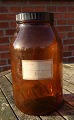 Large and well-maintained 5 liter apothecary 
bottle in dark brown glass. Labeled "322722" and 
"Pulvis Dentifricius Camphoratus".