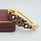 Bangle of 18k 
gold set with 
opal, a ruby, 
and blue ...