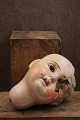 Old doll head in painted papier-mâché...