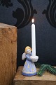 L. Hjorth glazed ceramic angel in blue and yellow color holding a small candle. 
H: 9.5cm.