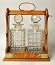 Pegasus – Kunst - Antik - Design presents: English tantalus with two crystal decanters, 19th century.