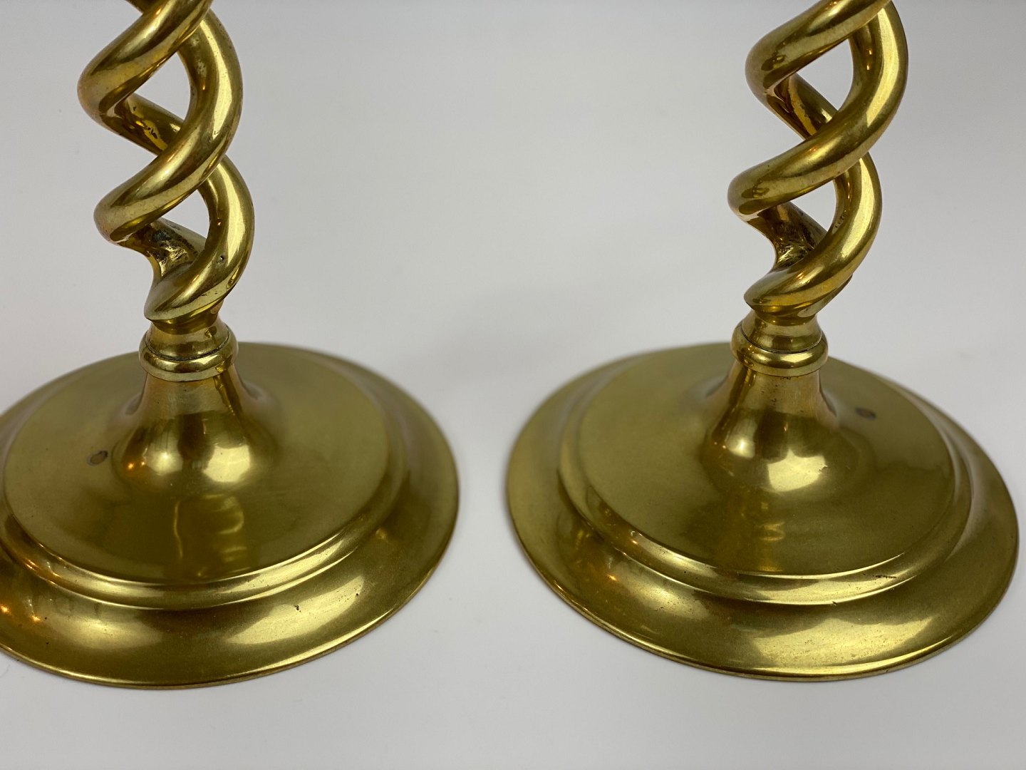 TWO PAIRS OF BRASS TWIST CANDLESTICKS