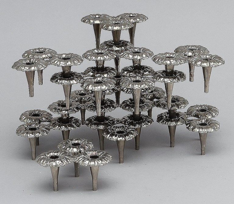 13 design candlesticks in white metal, can be assembled into modules.
