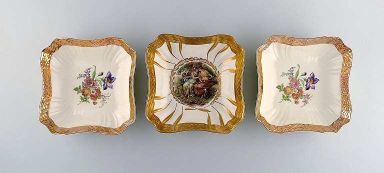 Royal Copenhagen. Three bowls with flowers and romantic scenes. Gold decoration. 
20 c.

