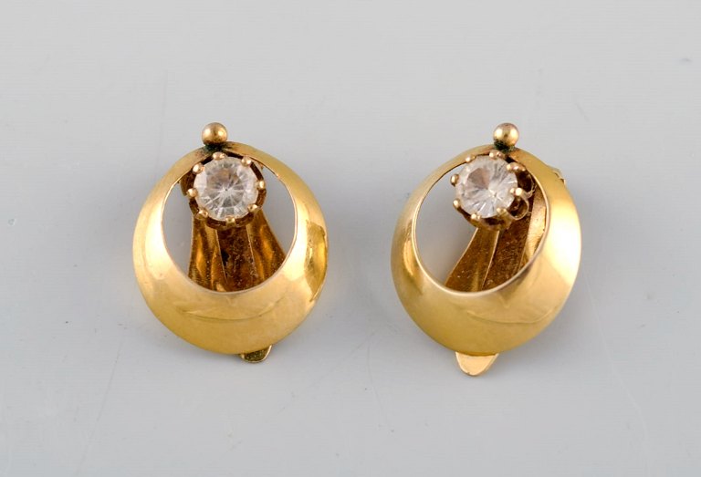 Scandinavian jeweler. A pair of 14 carat gold ear clip earrings with 
semi-precious stones. Mid 20th century.
