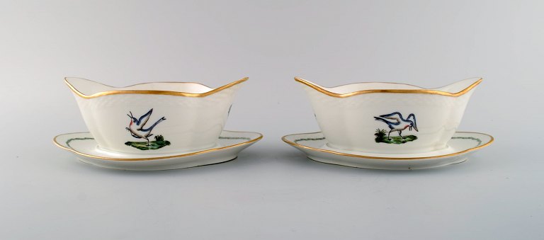 To Royal Copenhagen sovseskåle i håndmalet porcelæn med fuglemotiver og 
gulddekoration. Tidligt 1900-tallet.  
