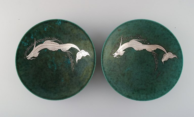 Wilhelm Kåge for Gustavsberg. Two rare Argenta art deco bowls in glazed ceramics 
decorated with fish in silver inlay. Sweden 1940