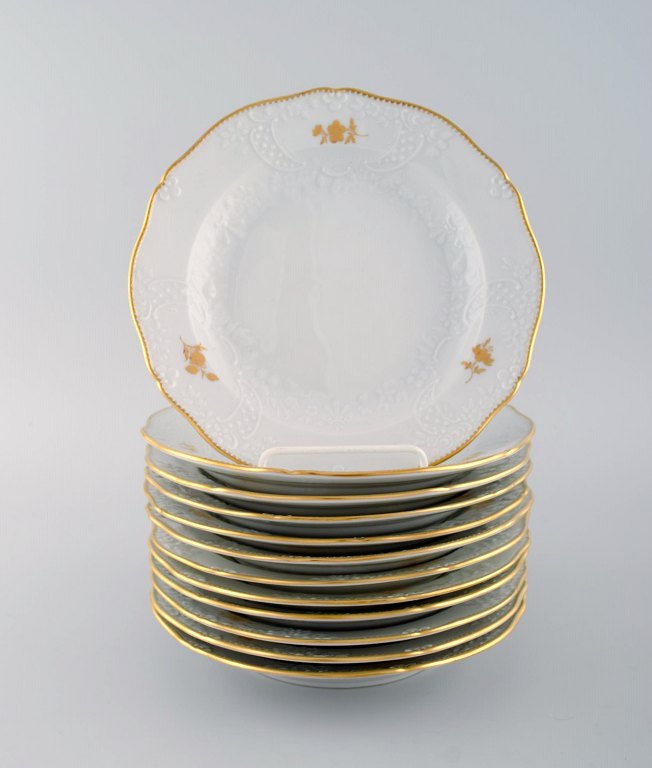 12 Meissen tallerkener med blomster og bladværk i relief og guldkant. 
1900-tallet.
