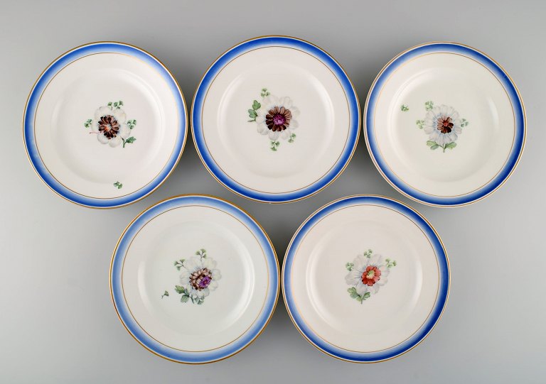 Fem antikke Royal Copenhagen tallerkener i håndmalet porcelæn med blomster og 
blå kant med guld. Modelnummer 592/9052. Sent 1800-tallet. 

