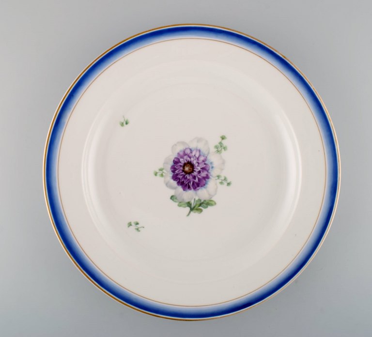 Large round antique Royal Copenhagen dish in hand-painted porcelain with flowers 
and blue edge with gold. Model number 592/9042. Late 19th century.
