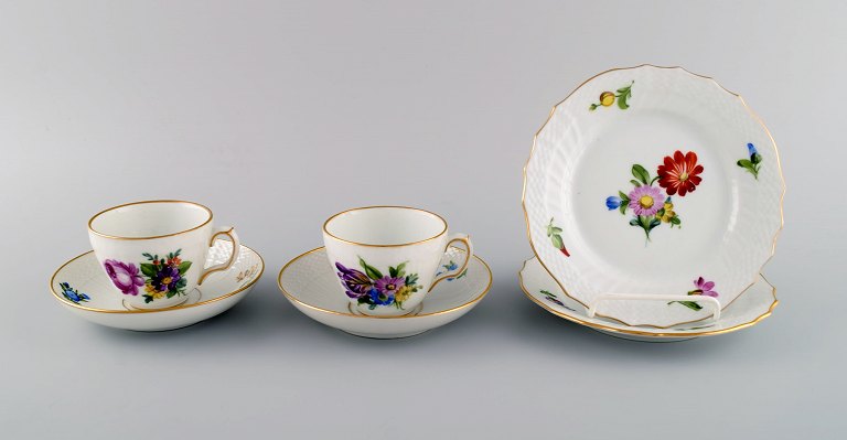Two Royal Copenhagen Saxon Flower coffee cups with saucers and two plates.
