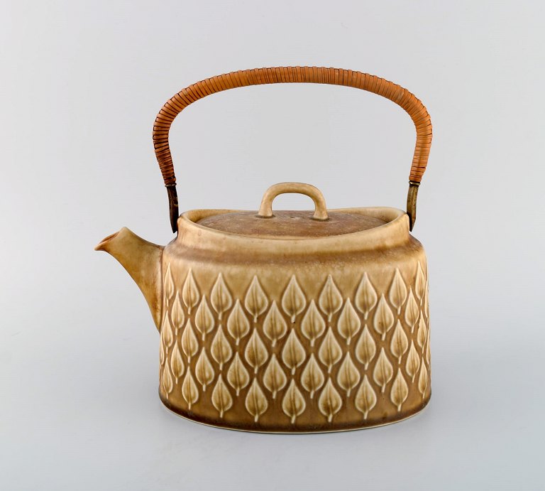 Jens H. Quistgaard (1919-2008) for Bing & Grondahl. Relief teapot in glazed 
stoneware with wicker handle. 1960