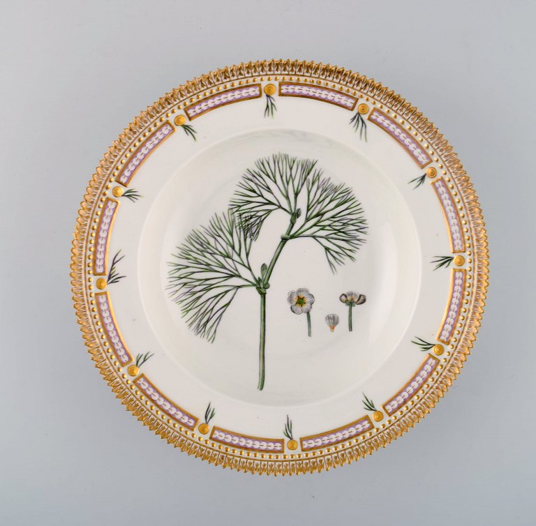 Royal Copenhagen flora danica dyb tallerken i porcelæn med håndmalede blomster 
og gulddekoration. 
