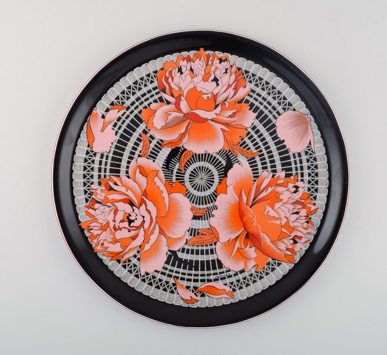 Stort rundt Hermès serveringsfad i porcelæn dekoreret med røde blomster på 
sort/hvid mønstret baggrund. 1980erne.
