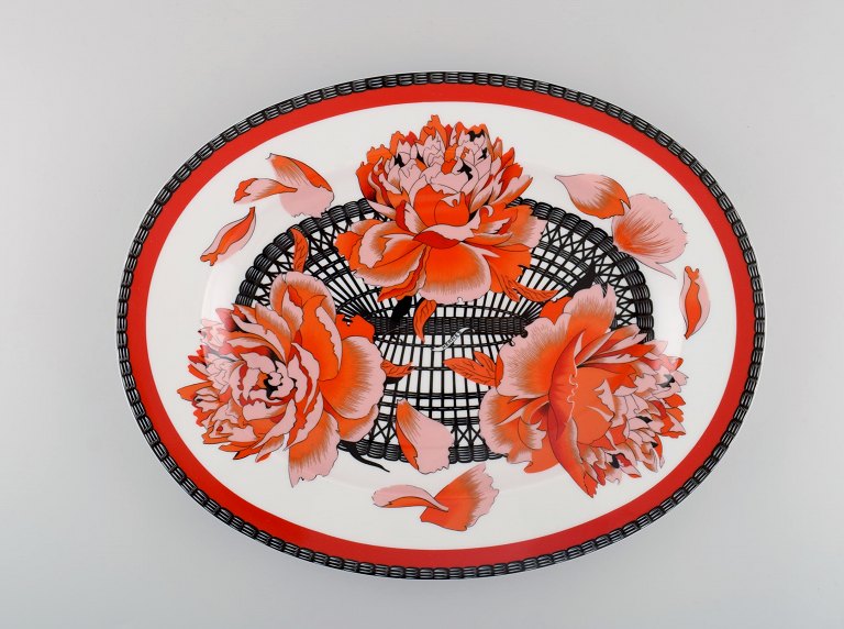 Stort Hermès serveringsfad i porcelæn dekoreret med røde blomster og sort/hvid 
mønstret dekoration. 1980erne.
