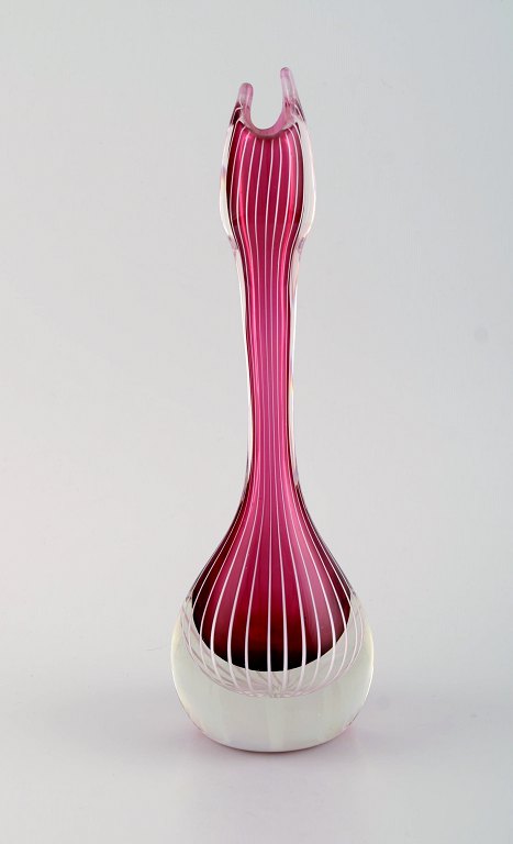 Swedish glass artist. Organically shaped vase in violet and clear mouth blown 
art glass with white stripes. Swedish design, mid 20th century.
