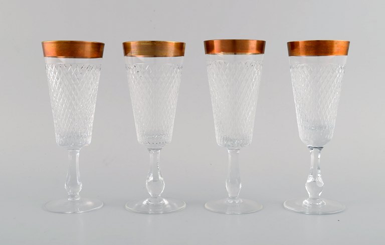 Four champagne glasses in mouth-blown crystal glass with gold edge. France, 
1930s.
