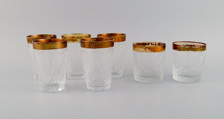 Seven drinking glasses in mouth-blown crystal glass with gold edge. France, 
1930s.
