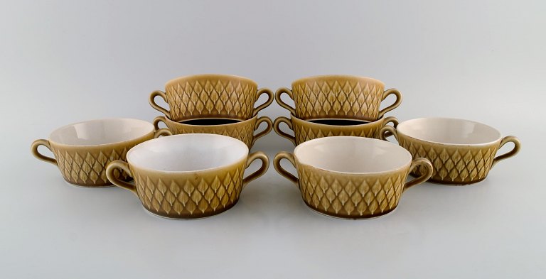 Jens H. Quistgaard (1919-2008) for Bing & Grøndahl. Eight Relief bouillon cups 
in glazed stoneware. Beautiful glaze in mustard yellow shades. 1960s.

