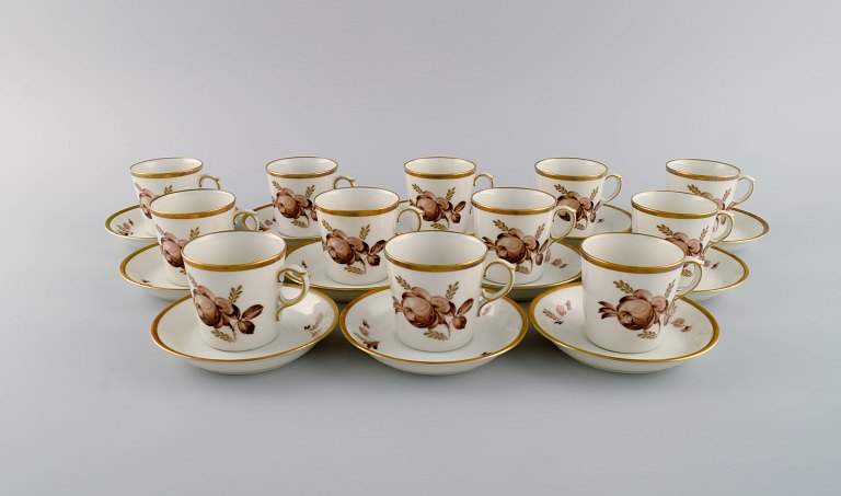 12 Royal Copenhagen Brown Rose mocha / coffee cups with saucers in hand-painted 
porcelain with flowers and gold edge. Dated 1968.
